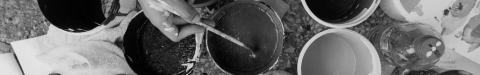 Overhead view of hands holding coffee cups in a circle, black and white photograph